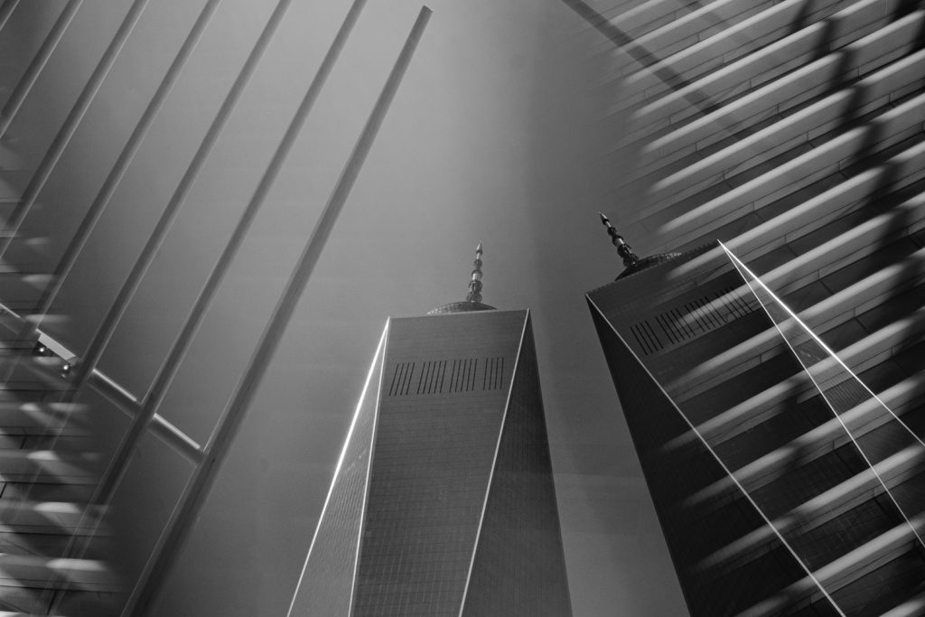 One word trade center tower duplicated like Twin Towers in prism with the wings of the Oculus Train Station surrounding them. 