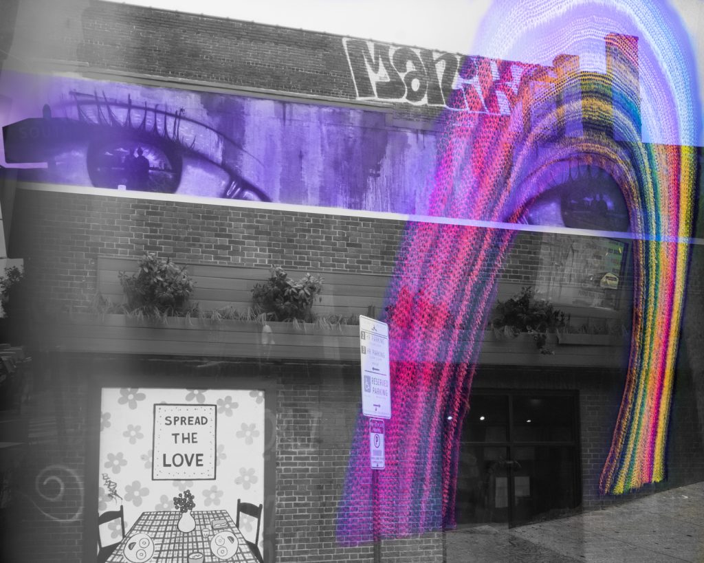 Prism photo of Mural painting over spread bagelry on south street Philadelphia of eyes with rainbow yarn bomb arching over one eye.